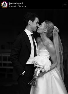 a bride and groom kissing each other in black and white