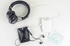 the headphones are laying on top of each other next to a wallet and tag