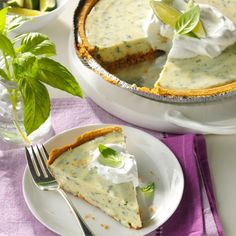 a piece of pie on a white plate with a fork and purple napkin next to it