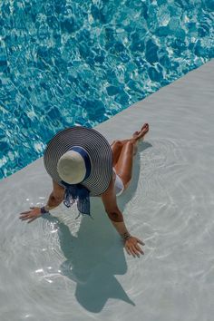 A woman sitting in a shallow pool with a big sun hat on for her resort capsule wardrobe. Resort Capsule Wardrobe, Beach Nails 2023, Vacation Beach Nails, Airport Look Summer, Year Capsule Wardrobe, Summer Vacation Necessities, Airport Outfit Summer, Chic Capsule Wardrobe, Cute Vacation Outfits