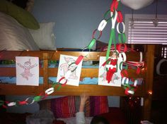 a child's hand is on the bottom bunk bed with paper decorations hanging from it