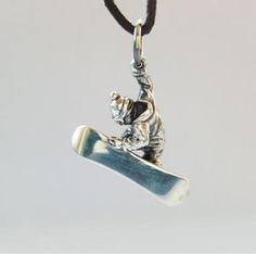 a silver pendant with a snowboarder on it