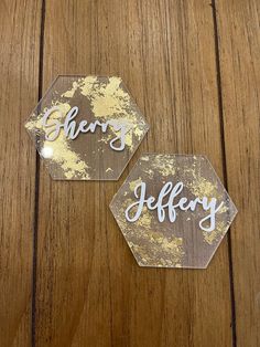 two hexagons with the words sorry and hilfray on them sitting on a wooden surface