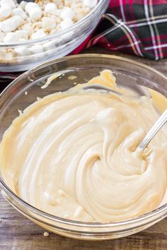 a bowl filled with batter and marshmallows on top of a wooden table