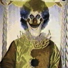 a creepy clown is standing in front of a curtain