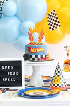 a table topped with cake and balloons next to a sign that says need four speed