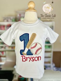 * A sweet first birthday top for boys.   * The design is sewn with 1 in blue fabric, with a bat and baseball Astros Birthday Shirt For Boys, Birthday Baseball Shirt, Team Spirit T-shirt For Birthday During Baseball Season, Baseball First Birthday Party T-shirts & Tank Tops, Toddler Baseball Shirt, Baseball Theme Birthday, Boys First Birthday Party Ideas, Baseball Theme, Children's Boutique