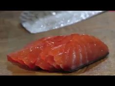 a piece of salmon sitting on top of a wooden cutting board