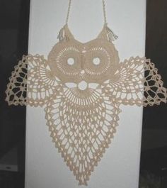 an owl is hanging on the wall with a crochet doily pattern around it