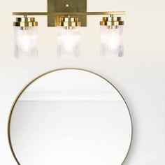 a bathroom with a round mirror and two lights