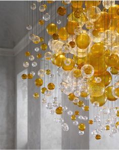 a chandelier with yellow glass balls hanging from it's sides in a room