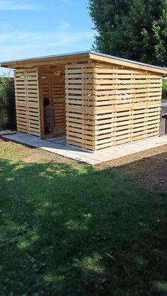 a small wooden building sitting on top of a lush green field