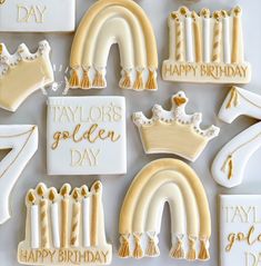 decorated cookies in the shape of royal crowns and rainbows with happy birthday written on them