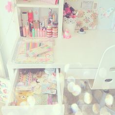 a white desk with lots of crafting supplies on it and an open bookcase