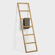 a wooden ladder leaning against a wall with a towel on it's back end