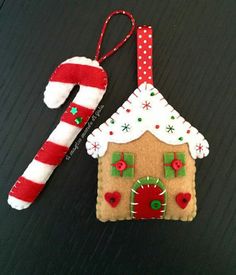 an ornament shaped like a gingerbread house and candy cane on a table