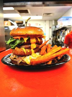 a hamburger and french fries on a black plate