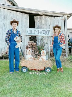 two people standing in front of a chicken coop with hay and chickens on the wagon