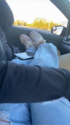 a person sitting in the back seat of a car with their feet propped up on his lap