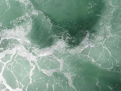 an aerial view of the ocean with green water