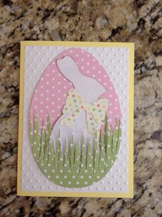 a card with an easter bunny in the grass and polka dots on it's side