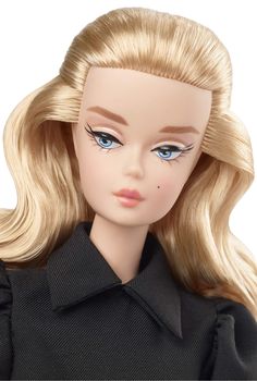 a doll with blonde hair and blue eyes wearing a black dress shirt is looking at the camera