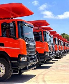 a row of orange trucks parked next to each other