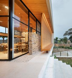 the outside of a modern home with stone and wood