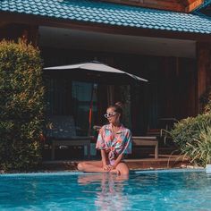 a woman sitting on the edge of a swimming pool