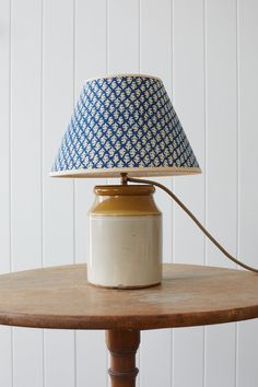 a blue and white lamp sitting on top of a wooden table