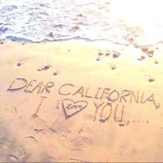 i love you written in the sand at the beach with footprints and hearts on it