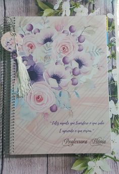 a note book with flowers and a tassel hanging from it's front cover