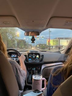 two people driving in the back seat of a car