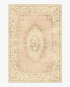 a beige rug with an ornate design on the center and sides, in various colors