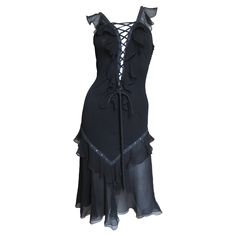 A gorgeous black silk dress by John Galliano for Christian Dior. The body of the dress is made of fine black stretch silk with functional adjustable lacing at the center front and back from the neckline through to the waist framed in a semi sheer ruffle. The skirt portion has an inset of 2 flared semi sheer silk layers from the thighs to the hem. The body of the dress is lined in the same fabric and has the Dior signature small self covered buttons along one side. Fits sizes Small, Medium. Marked US size 10. Bust 32-36" Waist 28-32" Hips Open Length 42" Newspaper Print Dress, Dior By John Galliano, Dior Clothing, Black Silk Dress, Cocktail Dress Vintage, Lace Up Dress, 40s Fashion, Corset Lace, Princess Outfits