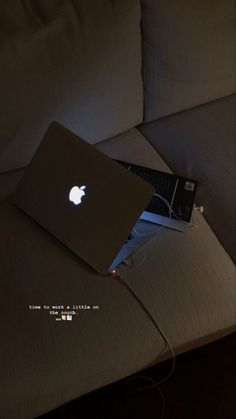 an apple laptop sitting on top of a couch