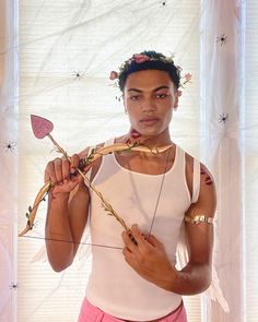 a woman is holding an arrow in front of her face