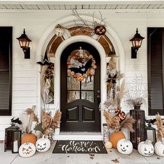 a front door decorated for halloween with pumpkins and other decorations