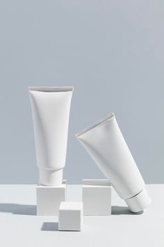 two white vases sitting next to each other