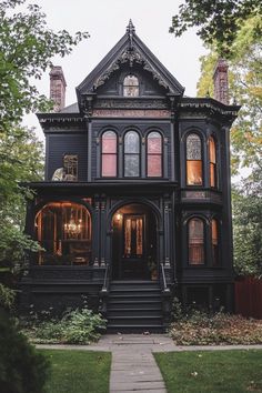 an old victorian style house with black trim and red shutters on the front door