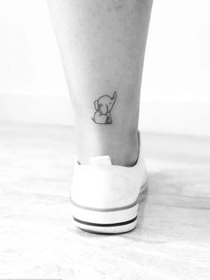 a small tattoo on the ankle of a woman's foot, with an elephant