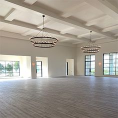 an empty room with chandeliers and windows