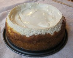 a cake sitting on top of a black plate covered in frosted icing next to a white table cloth