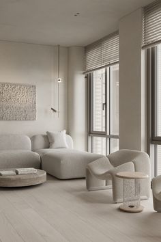 a living room with white furniture and large windows