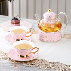 three pink tea cups and saucers on a table