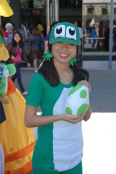 a woman in a green and white costume holding a stuffed animal