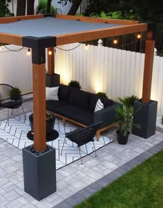 an outdoor living area with black furniture and lights