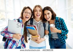 three young women are smiling and holding folders in their hands while looking at the camera