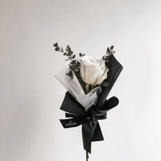 a bouquet of white roses tied to a black ribbon