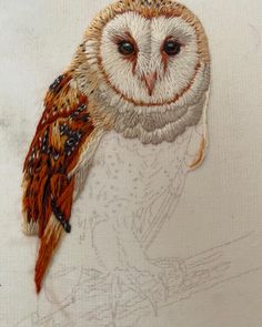 an embroidered owl sitting on top of a piece of cloth